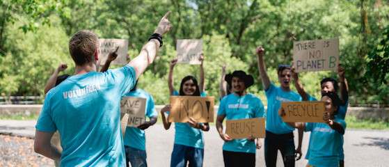 Volunteers protest and hold a sign to make everyone save the world in the forest park area., Environmental protection project.