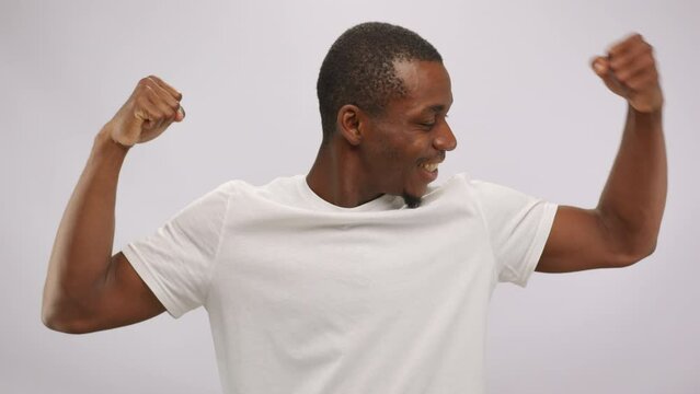 African American man demonstrates power and strength showing muscles in studio