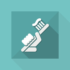 Hand holding toothpaste and toothbrush