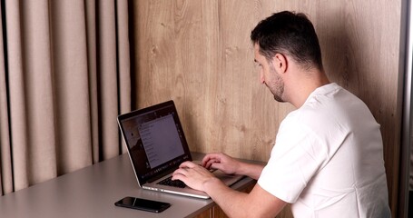 A man working on a laptop at home.