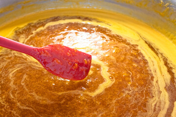 Boiling traditional delicious fragrant apricot jam in a large aluminum bowl