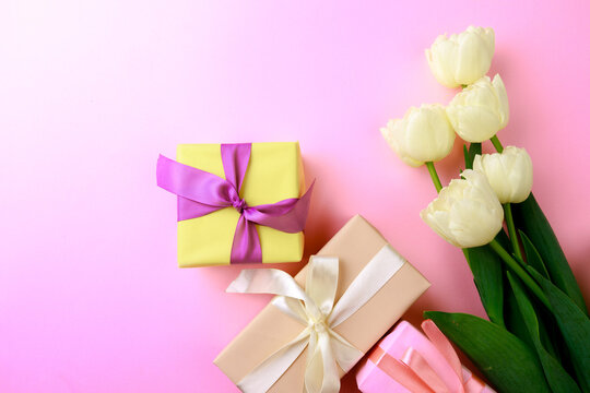 Gift box and spring flowers on pink background. Stylish soft image of spring flowers. Happy womens day. Happy Mothers day.Hello Spring- Image