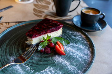 Cherry cheesecake, summer berry decoration, on a ceramic plate