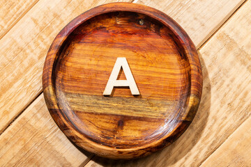 Letter A of the alphabet in a wooden bowl