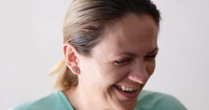 Young woman laughs to tears, face close-up