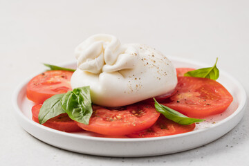 Tomato salad with buratta cheese or mozzarella and basil. Traditional italian salad, mediterranean cuisine