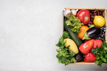 Fresh vegetables and fruits in cardboard box on white background. The concept of food delivery,...