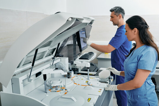 Diagnostic laboratory scientists researching on blood samples using modern technology and medical research machines