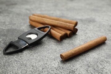 Cigars and guillotine cutter on grey table