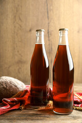 Bottles of delicious fresh kvass, spikelets and bread on wooden table