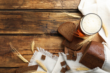 Flat lay composition with delicious kvass, spikes and bread on wooden table, space for text