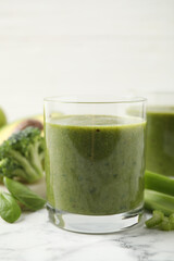 Delicious fresh green juice on white marble table, closeup