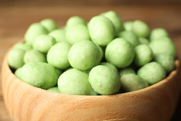 Tasty wasabi coated peanuts in bowl, closeup