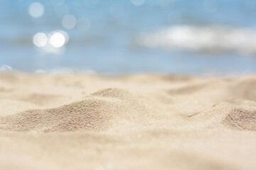 Fototapeta na wymiar Sandy beach near sea on sunny day, closeup