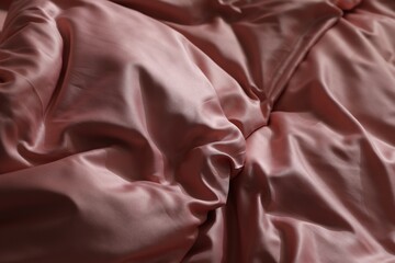 Closeup view of bed with beautiful pink silk linens