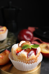 Delicious cupcakes with plums on black table, closeup