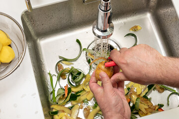 Cleaning vegetables over the sink with waste in the dispenser