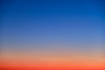 Orange and blue sunset sky gradient, copy space background. Red evening sky without clouds