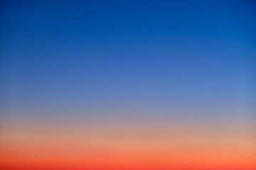 Fototapeta premium Orange and blue sunset sky gradient, copy space background. Red evening sky without clouds