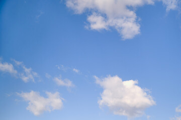 White cumulus clouds in the blue sky. Bright beautiful sky, copy space background