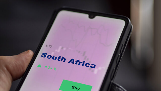 An Investor's Analyzing The South Africa Etf Fund On Screen. A Phone Shows The ETF's Prices South African To Invest