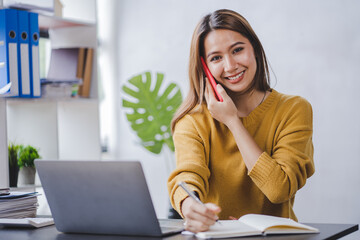 Asian businesswoman talking on smartphone and working in office Asian businesswoman sitting at his office