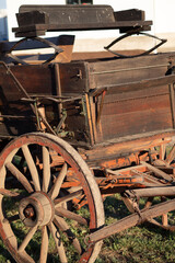 Fototapeta na wymiar This is closeup, digitally enhanced image of a buckboard wagon originally from the Oregon ghost town, Shaniko. Evening sunlight accentuates the oranges and browns of the weathered surfaces.
