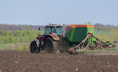 Tractor with a seeder to sow crops in an agricultural field