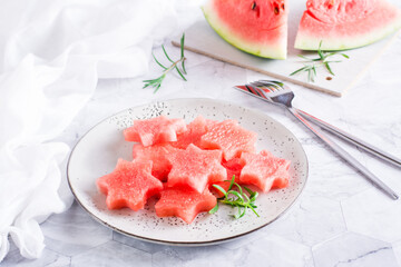 Ripe watermelon stars on a plate on the table. Summer refreshment.
