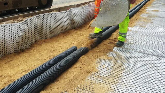 Groundworkers installing new electric ducts during roadworks