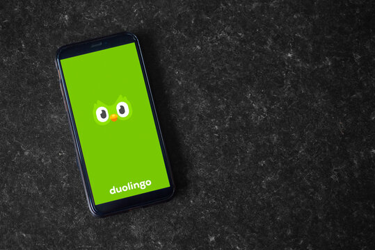 UK, Newcastle, August 21, 2022: The Duolingo Logo On The Screen Of A Modern Smartphone, Which Lies On A Surface Of Artificial Stone