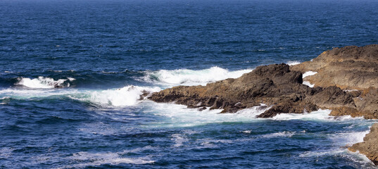 Rugged Rocks on a rocky shore on the West Coast of Pacific Ocean. Summer Morning Sky. Ucluelet, Vancouver Island, British Columbia, Canada. Nature Background