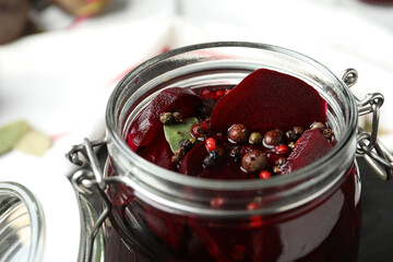 Pickled beets in glass preserving jar on table, closeup