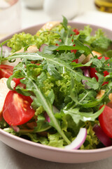 Delicious salad with chicken, arugula and tomatoes on table, closeup