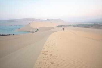 A female running on the top of a sand hill in Fayoum - Egypt. 