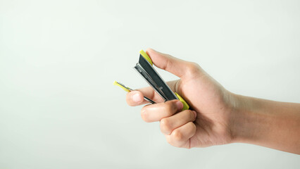 Man holding a green stapler on a white background.