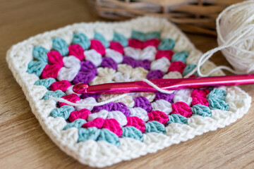 close uo colorful granny square with pink crochet hook