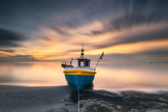 Fototapeta Tytuł: Sopot, morze bałtyckie. Wschód słońca nad kutrem rybackim z widokiem na morze i plażę. Baltic see, sunrise
