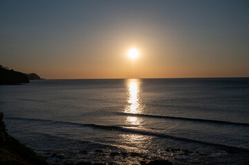 Fototapeta premium Sunset in calm waters of Atlantic ocean and clear sky