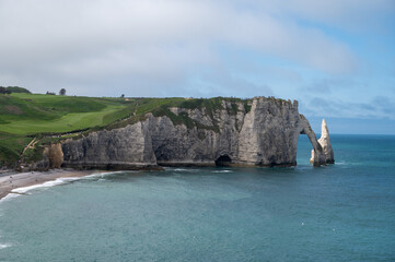 Panoramic view on chalk cliffs and Porte d'Aval arch in Etretat, Normandy, France. Tourists destination.