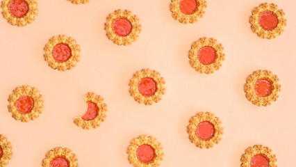 Fresh baked orange cookies pattern on beige background. Flat lay