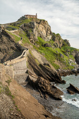 Stone footpath to famous landmark and film location in North of Spain, ocean islet with chapel San...