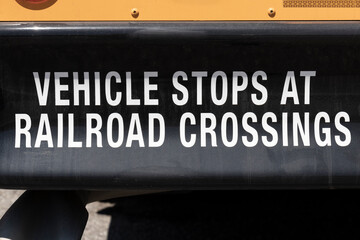 Vehicle Stops at Railroad Crossings sign on the back of a School Bus.