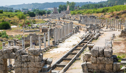 Fototapeta na wymiar Perge, Colonnaded street and a water channel runs in the middle of the street from the Nymphaion fountain. Dated by period of the Emperor Hadrian 334 BC. Turkey