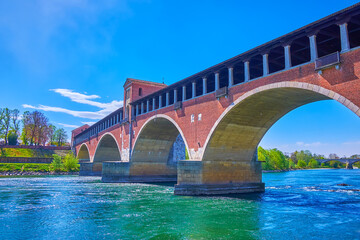 The stylish arched Ponte Coperto bridge in Pavia city, Italy