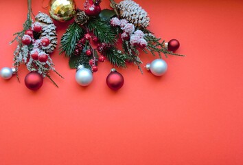 Christmas red decorations, fir branches on a red background. Copy space. Christmas flatly.	