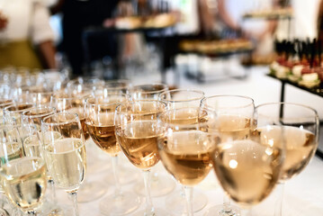 many glasses of white wine stand in a row on the table