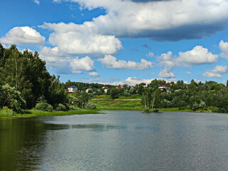 Fototapeta na wymiar Summer clouds over a pond near Moscow
