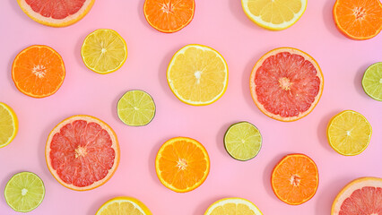 Fototapeta na wymiar Creative summer pattern with sliced citrus fruits on pastel pink background. Flat lay