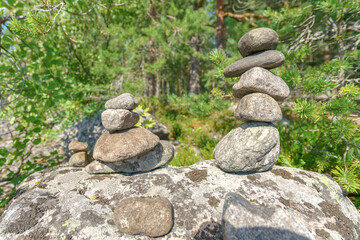 Fototapeta na wymiar Pyramid of stones. Unstable balance of stone objects. Idyllic state of nature.